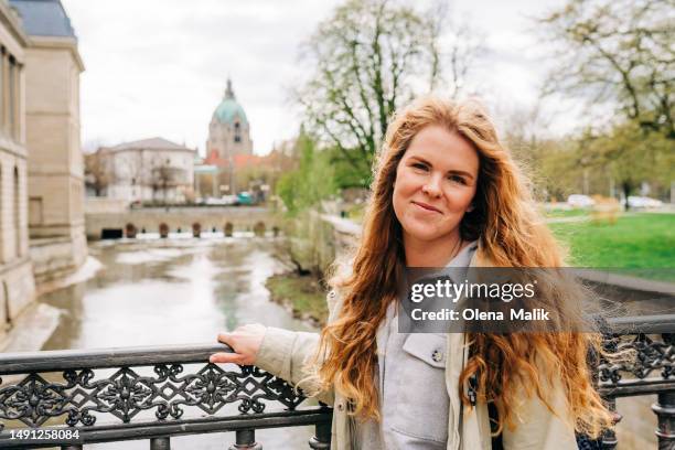 happy redhead woman walking in old town in hannover, germany - hanover germany stock-fotos und bilder