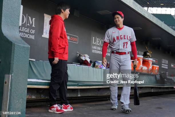 Shohei Ohtani of the Los Angeles Angels talks with his translator, Ippei Mizuhara, before a game against the Baltimore Orioles at Oriole Park at...