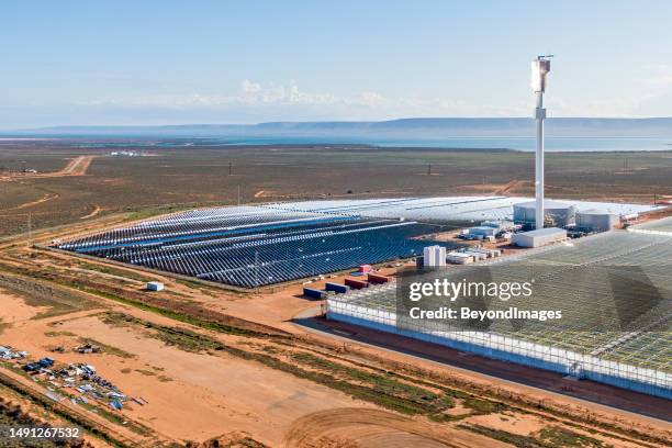 aerial view sundrop concentrated solar power (csp) plant with associated greenhouse & spencer gulf backdrop - south australia copy space stock pictures, royalty-free photos & images