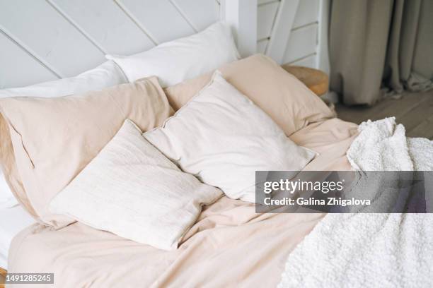 beige cotton bed linen pillows blanket on wooden eco style bed in bedroom at home - hotel room white bed stock pictures, royalty-free photos & images