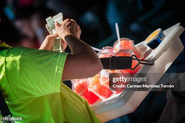 fresh slush vendor at baseball game counting the money. - straßenverkäufer stock-fotos und bilder