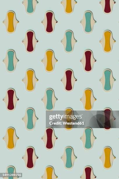 3d pattern of colorful sanitary pads flat laid against green background - menstruation stock illustrations