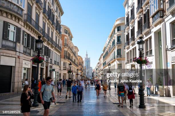 People walk along the Calle Marqués de Larios in the old town on April 16, 2023 in Malaga, Spain.