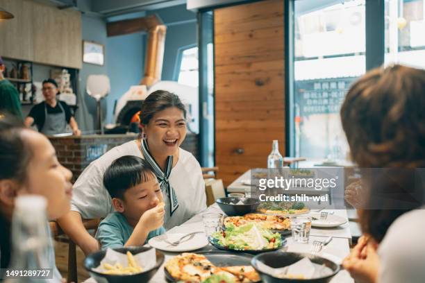 eine familie aus asien besucht eine pizzeria, um leckeres essen zu genießen, sich glücklich verwöhnen zu lassen und die wunderbaren momente der zweisamkeit zu genießen. - taiwanesischer abstammung stock-fotos und bilder