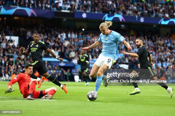 Erling Haaland of Manchester City in action with Thibaut Courtois of Real Madrid during the UEFA Champions League semi-final second leg match between...