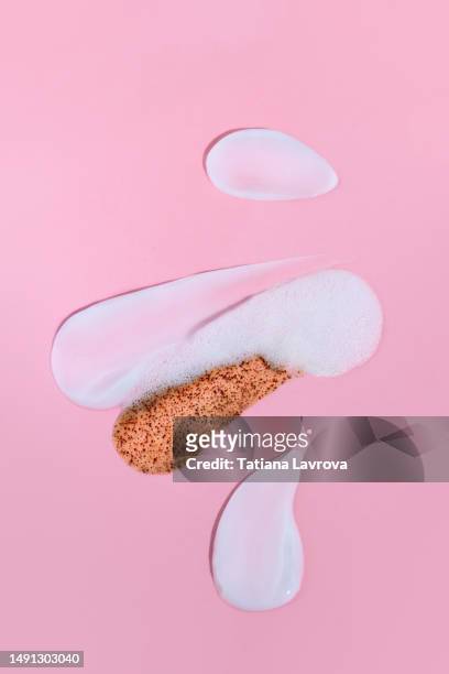 set of textured beauty products on pink background. brown body scrub, white face cream, foam and gel moisturizer for healthy skin - body scrub stock-fotos und bilder