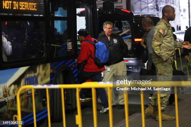 Asylum seekers board a bus en route to a shelter at Port Authority Bus Terminal on May 18 in New York City. Mayor Eric Adams addressed the daily...