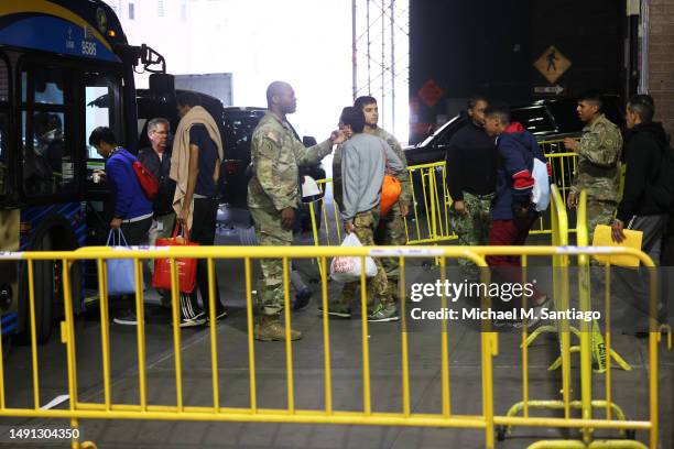 Asylum seekers board a bus en route to a shelter at Port Authority Bus Terminal on May 18 in New York City. Mayor Eric Adams addressed the daily...