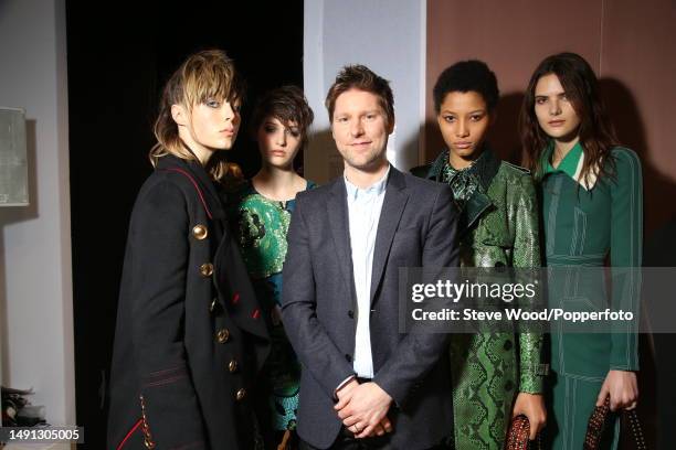 Backstage at the Burberry show during London Fashion Week Autumn/Winter 2016/17, Burberry Creative Director Christopher Bailey is flanked by models...