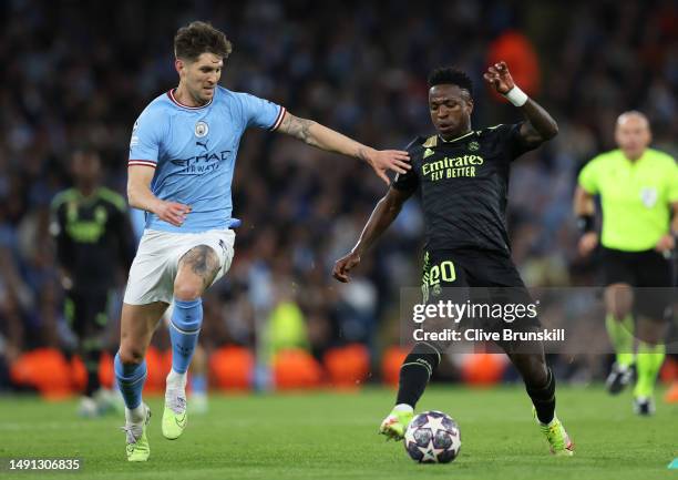 John Stones of Manchester City attempts to stop Vinicius Junior of Real Madrid during the UEFA Champions League semi-final second leg match between...