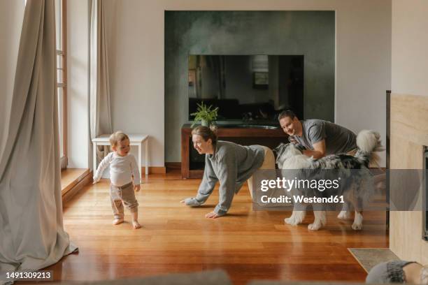 playful family spending leisure time in living room - gatear fotografías e imágenes de stock