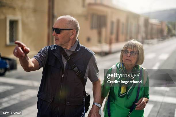 senior couple lost in a small italian town of tropea - weg wijzen stockfoto's en -beelden