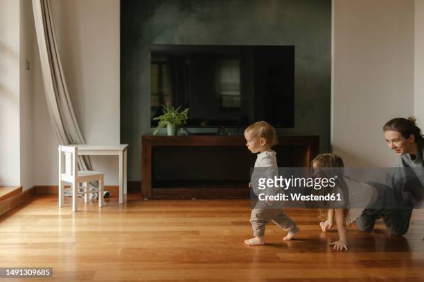 family playing on hardwood floor at home - 這う ストックフォトと画像