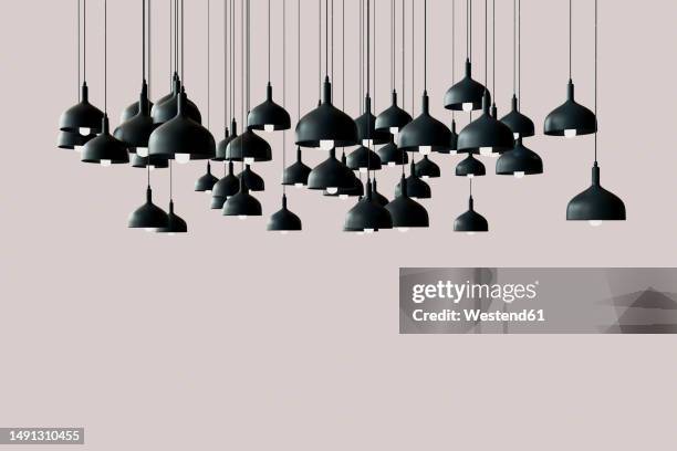 3d render of black light fixtures hanging against pink background - hängelampe stock-grafiken, -clipart, -cartoons und -symbole