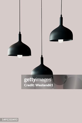 3D render of three black light fixtures hanging against pink background 3D render of three black light fixtures hanging against pink background