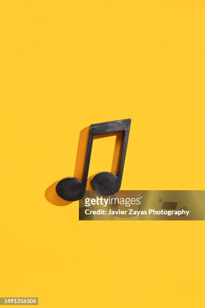 musical note quaver on yellow background - 3d music notes stock pictures, royalty-free photos & images