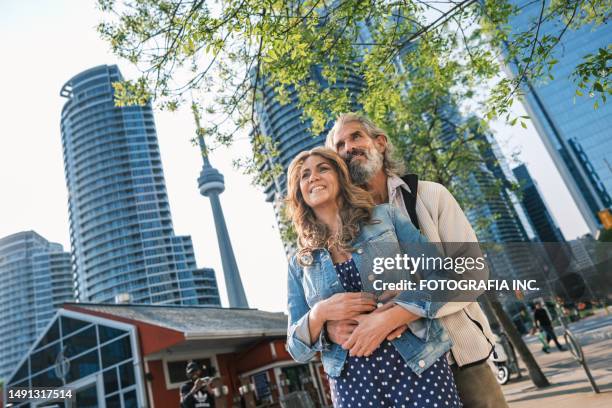 senior mixed race couple sightseeing downtown toronto lake shore - daily life in toronto stock pictures, royalty-free photos & images