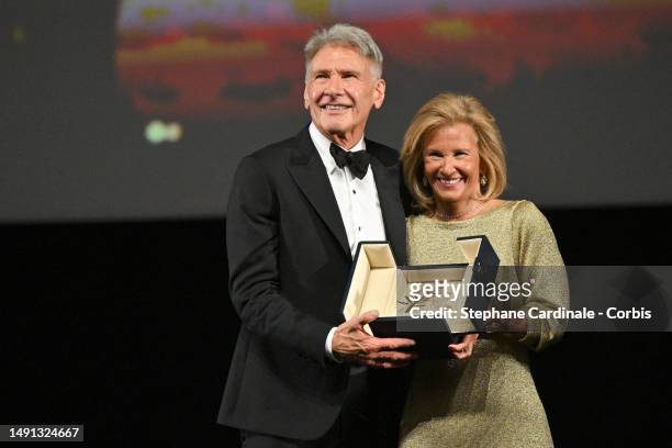 Harrison Ford receives an honorary Palme D'Or from Iris Knobloch during the 76th annual Cannes film festival at Palais des Festivals on May 18, 2023...