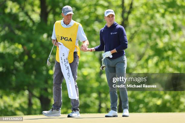 Justin Thomas of the United States waits with caddie Jim 'Bones' Mackay on the 14th hole during the first round of the 2023 PGA Championship at Oak...