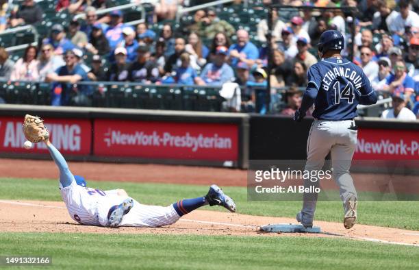 Christian Bethancourt of the Tampa Bay Rays reaches first base safely after Pete Alonso of the New York Mets cannot hold onto the ball during their...