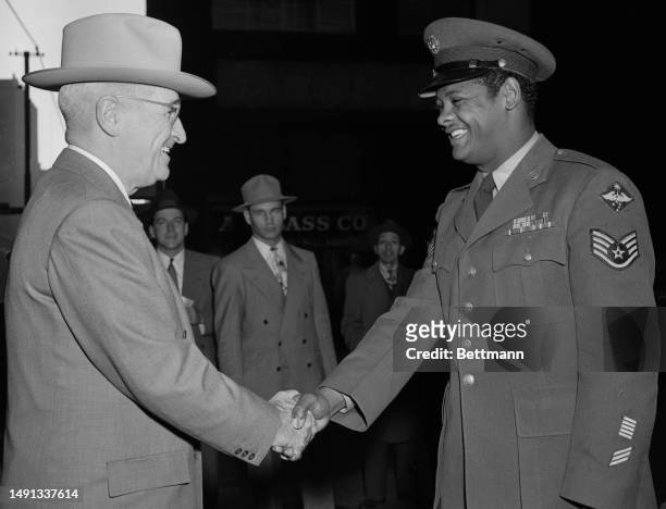Air Force's Staff Sgt. Edward Williams, of St. Louis exchanges a hearty handshake with his Commander-In-Chief President Harry Truman at a casual...