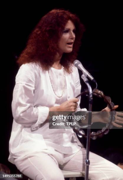 Swedish singer and songwriter Anni-Frid Lyngstad, of the supergroup ABBA, plays the tambourine on stage during the Olivia! TV Special at The Columbia...