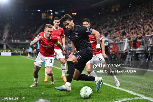 Lucas Paqueta of West Ham United is put under pressure by Jordy Clasie and Tijjani Reijnders of AZ Alkmaar during the UEFA Europa Conference League...