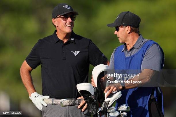 Phil Mickelson of the United States waits with caddie Tim Mickelson on the ninth tee during the first round of the 2023 PGA Championship at Oak Hill...