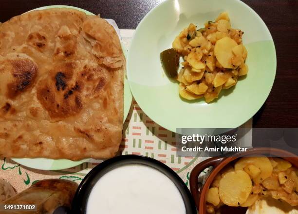 oily flatbread paratha served with potatoes curry. - parantha stock-fotos und bilder