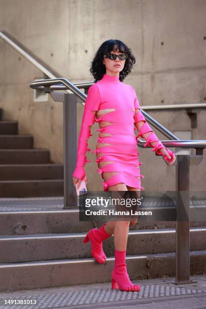 Charlene Davies wearing hot pink cut off detailed wrap dress and shock boots at Afterpay Australian Fashion Week 2023 at Carriageworks on May 19,...