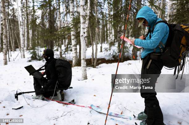 SnowEx researchers Dr. Kelly Gleason and master's student Sage Ebel work on skis while taking measurements of snow albedo in a section of boreal...