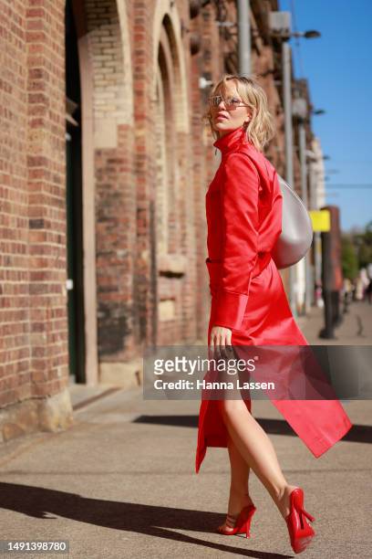 Violet Grace Atkinson wearing Ferragamo red jacket and midi skirt, red Ferragamo shoes and Givenchy grey bag at Afterpay Australian Fashion Week 2023...
