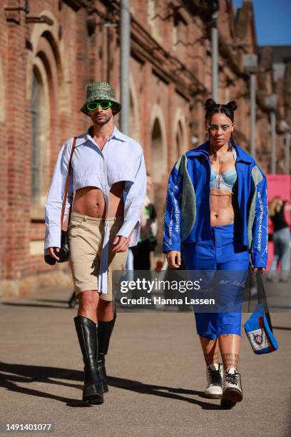 Guest wearing green bucket hat, cropped shirt, beige shorts and black leather boots and a guest wearing blue matching jacket and pants at Afterpay...