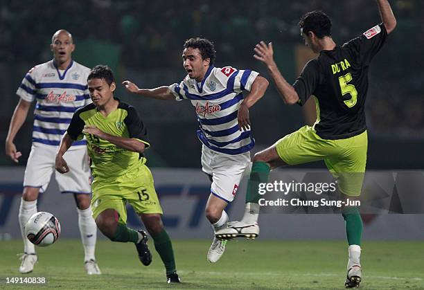 Fabio Da Silva of Queens Park Rangers tussles for posession with Otavio Dutra and Rivelino of Persebaya during the preseason friendly match between...