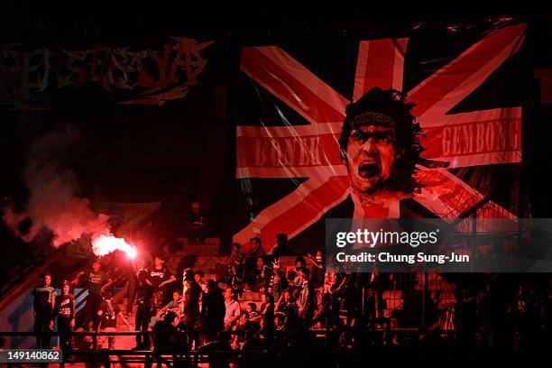 Fans set of flares during the preseason friendly match between Persebaya and Queens Park Rangers at Gelora Bung Tomo Stadium on July 23, 2012 in...