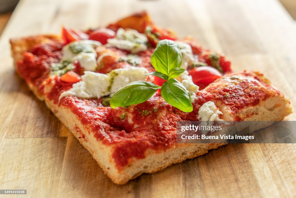 Slice of pizza with pesto and mozzarella cheese