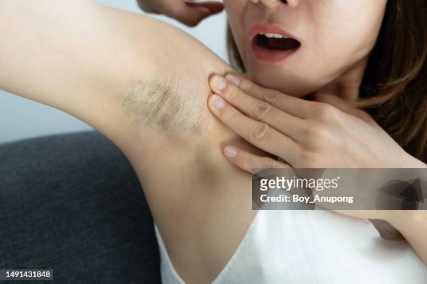 cropped shot of asian woman showing her unshaved armpit. - boy armpit stock-fotos und bilder