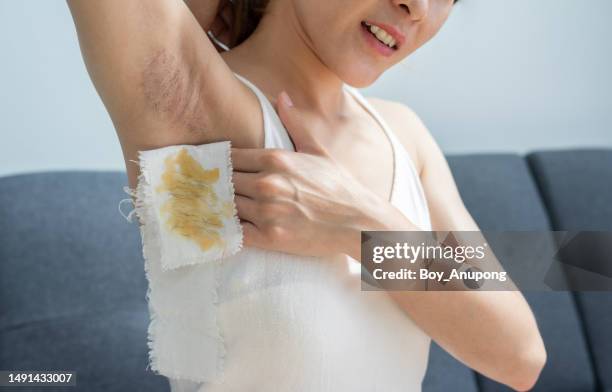 cropped shot of woman showing her diy wax strips after removal hair grows under her armpit by herself. - boy armpit stock-fotos und bilder