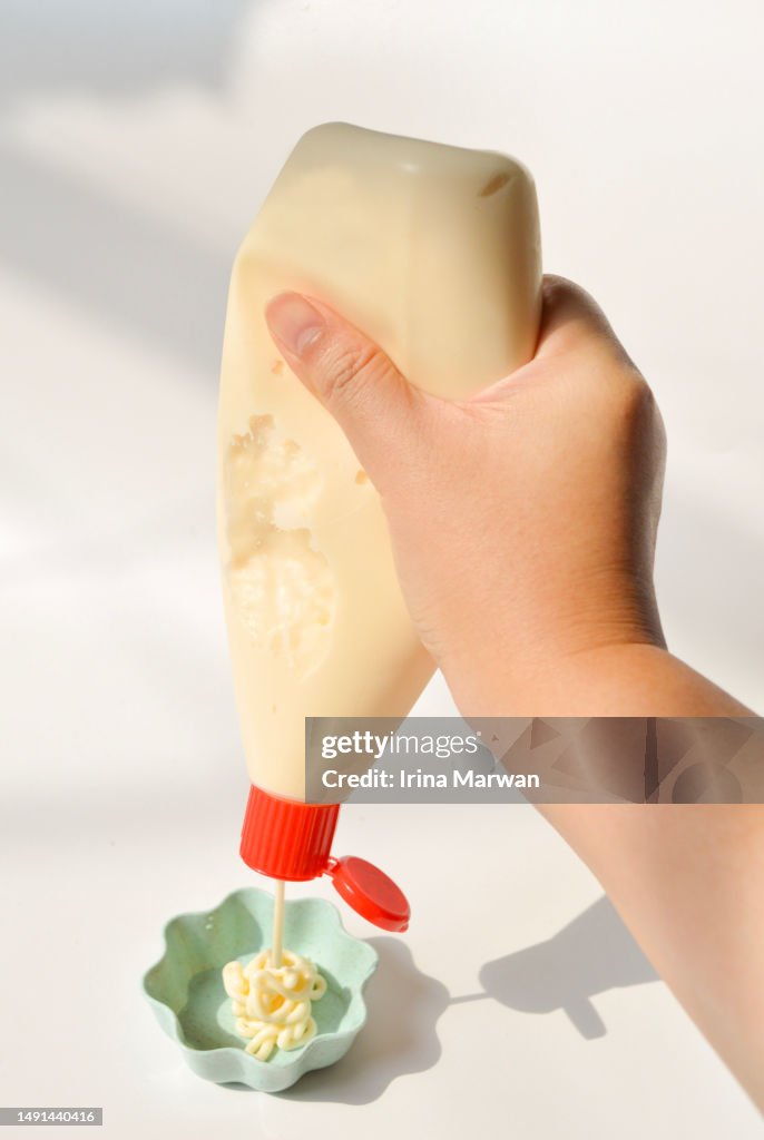 Pouring mayonaise from a squeeze bottle