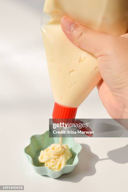 pouring mayonaise from a squeeze bottle - マヨネーズ ストックフォトと画像