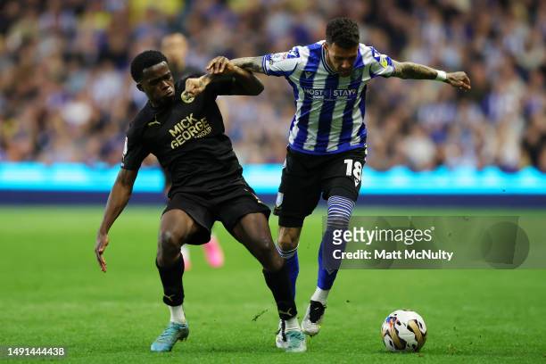Kwame Poku of Peterborough United battles for possession with Marvin Johnson of Sheffield Wednesday during the Sky Bet League One Play-Off Semi-Final...
