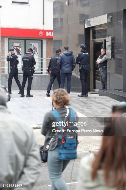 Police officers at the entrance of the building where two 12-year-old twin girls died today when they fell to their deaths from the patio of a...