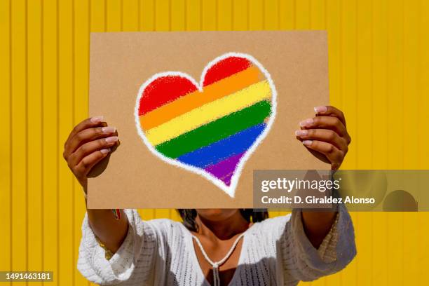 ainbow flag heart placard sign, symbol of lgbt - bi annual stock-fotos und bilder