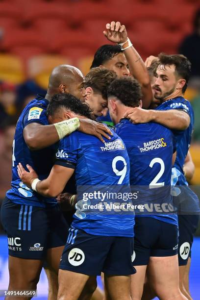 Beauden Barrett of the Blues celebrates with team mates after scoring a try during the round 13 Super Rugby Pacific match between Queensland Reds and...