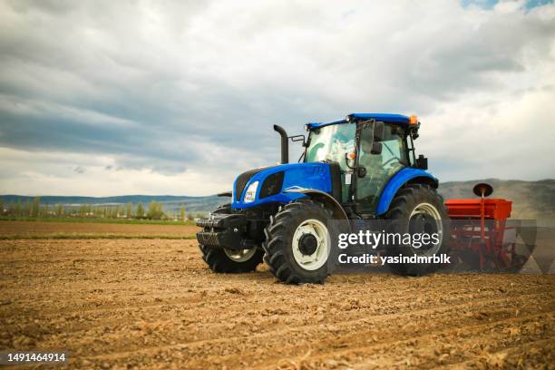 landwirt pflanzt saatgut mit traktor und sämaschine - traktor stock-fotos und bilder