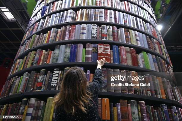 Woman holds a book near a book tower during the Turin Book Fair 2023 on May 19, 2023 in Turin, Italy. The Turin International Book Fair is the...