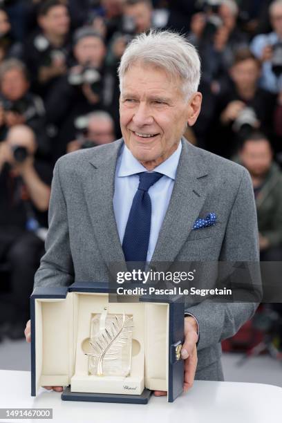 Harrison Ford poses with the honorary Palme D'Or he received, at the "Indiana Jones And The Dial Of Destiny" photocall at the 76th annual Cannes film...