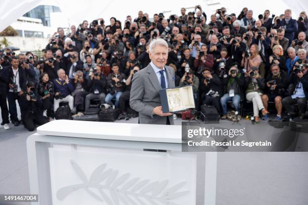 Harrison Ford poses with the honorary Palme D'Or he received, at the "Indiana Jones And The Dial Of Destiny" photocall at the 76th annual Cannes film...