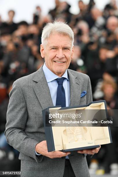 Harrison Ford shows the honorary Palme D'Or he received during the "Indiana Jones And The Dial Of Destiny" photocall at the 76th annual Cannes film...