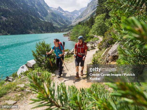 man and woman hiking in the high pyrenees near gaube lake, cauterets, france - occitanie - fotografias e filmes do acervo